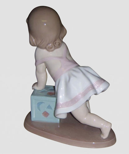 "My First Step" Lladro Figurine #6428 - Baby Girl with Block (6")