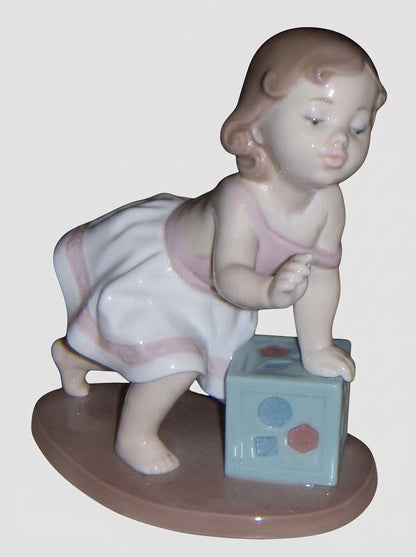 "My First Step" Lladro Figurine #6428 - Baby Girl with Block (6")