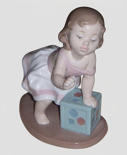 "My First Step" Lladro Figurine #6428 - Baby Girl with Block (6")