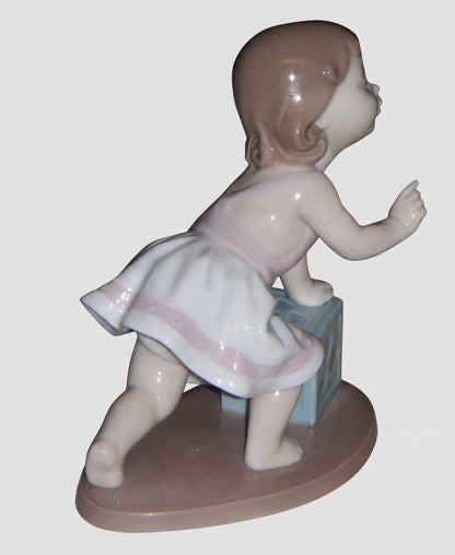 "My First Step" Lladro Figurine #6428 - Baby Girl with Block (6")